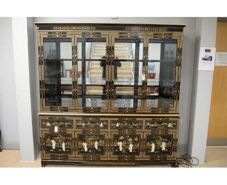 A 20th Century black lacquer painted and hardstone inlaid glazed display cabinet, the projecting cornice above four glazed cu