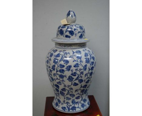 A Chinese blue and white jar and cover, with allover blue and white foliate meanders, finial top lid, 66cms.