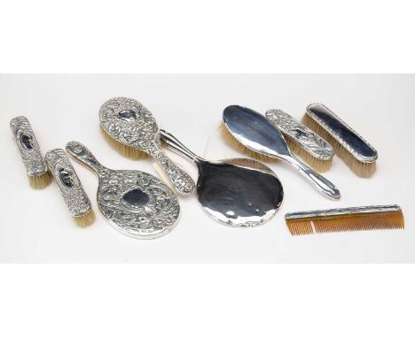 Silver-backed dressing table items, including: two hand mirrors; two hand brushes; four clothes brushes; and a comb, various 