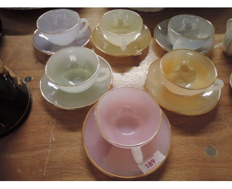 A selection of vintage pressed glass tea cups and saucers by Arcopal in a harlequin style