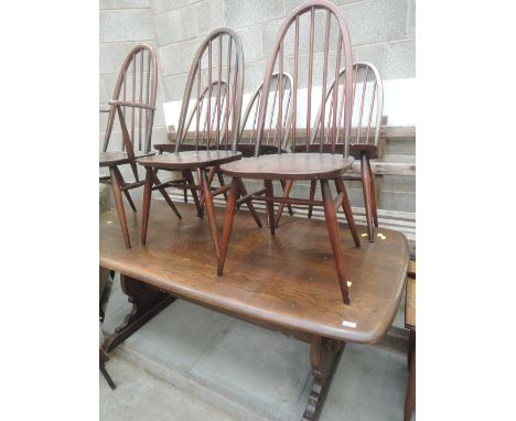 A dark stained Ercol style refectory table and set of 6 ( 5 plus 1 ) spindle back dining chairs