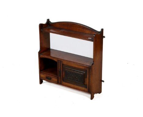 An Edwardian mahogany hanging wall cupboard. Having a moulded top, two shelves, a panelled cupboard and a single shelf, H63cm