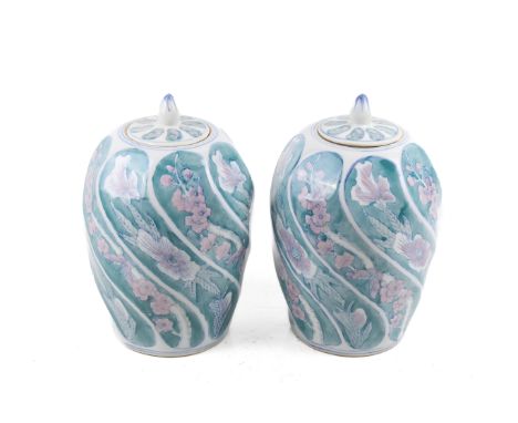 A pair of ceramic jars and covers. Glazed in blue and pink with floral decoration, H30cm***This lot is being sold on behalf o