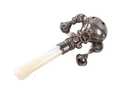 A silver and mother of pearl rattle. Of flattened form, the roundel pierced with small stars protruding from a stylised fleur