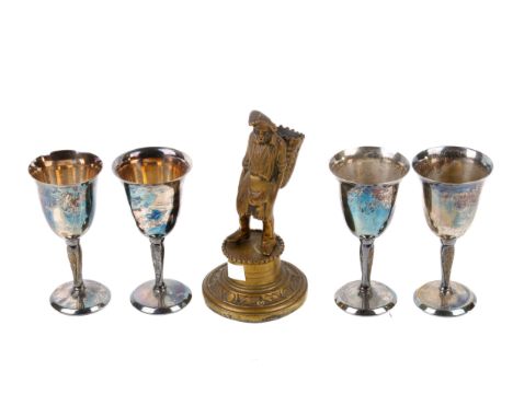 A late Victorian brass novelty bar top cigar lighter and four metal goblets. The first modelled as a figure of a man, with op