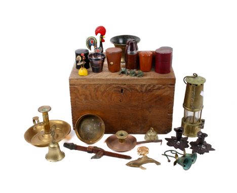 A collection of brass and copper items in an oak box.  Including miners lamp, candlestick, etc. Max. H28cm
