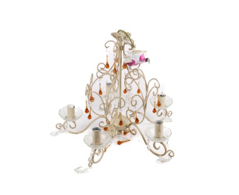 A contemporary chandelier. The metal frame coloured white with scrolling decoration and featuring multiple orange and clear g