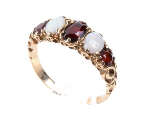 A 9ct opal and garnet ring. With three garnets flanking two oval opals in a scrolling mount, size N, weight 2.7g.
