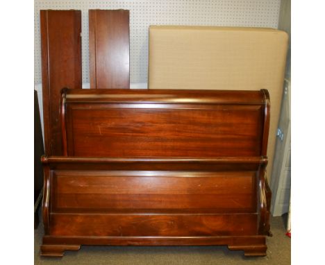 A mahogany framed sleigh bed. Having a curved headboard and footboard with panelled detailing, complete with supportive hardw