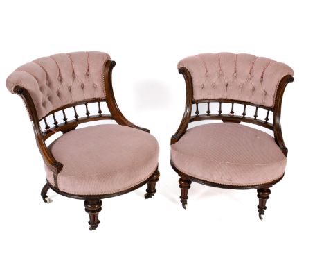 A pair of Victorian mahogany framed button back upholstered bedroom chairs. Oval shaped seats with turned tapering supports t