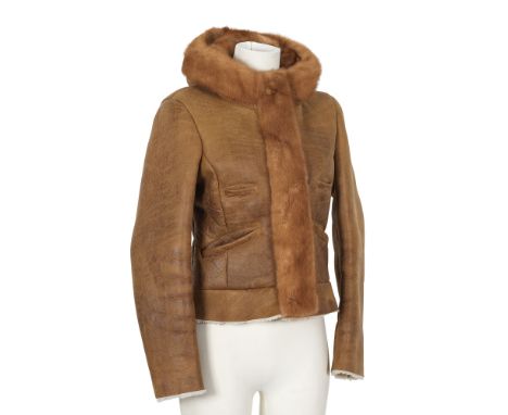PRADA. Blouson à capuche en peau lainée cannelle gansée de vison lustré à la couleur.Directeur artistique: Miuccia Prada.Ferm