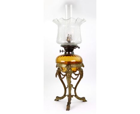 An amber glass oil lamp, 20th century, in 19th century style, with foliate glass shade and crimped neck, the gilt metal stand