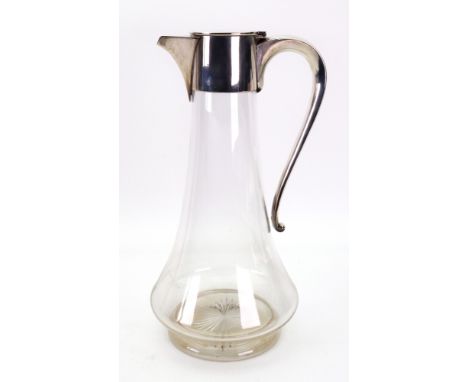 An Edwardian silver mounted clear glass claret jug, John Grinsell & Sons, London 1904, with flush hinged cover and scroll han