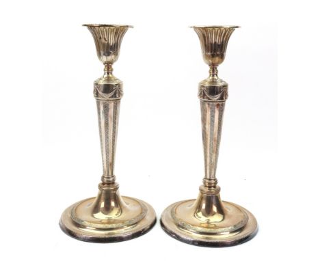 A pair of George III style electroplate candlesticks, with vase shape scones, a band of ribbon tied drapes, the tapering stem