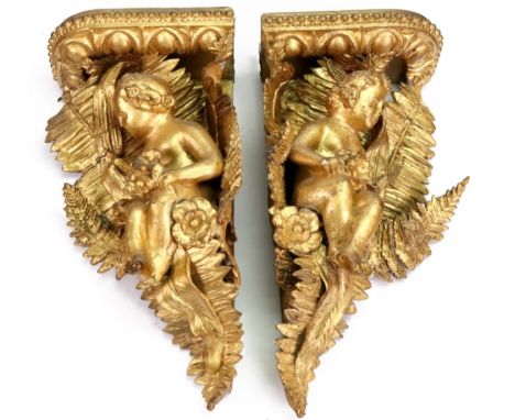 A pair of Victorian carved giltwood and gesso corner wall brackets, circa 1860, each with an infant figure seated amongst flo