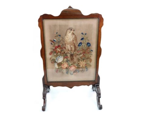 A Victorian walnut frame firescreen, circa 1870, of shaped outline, on scroll carved legs, inset with a glazed raised plush B