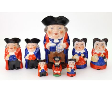 A group of eight Royal Worcester Toby Jugs, 1920's and later, including a miniature Mephistopheles jug, puce and black printe