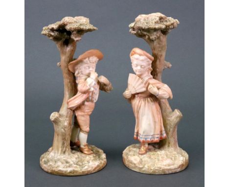 A pair of small Royal Worcester Kate Greenaway figures, 1880's, modelled by James Hadley, as a boy and girl standing before a