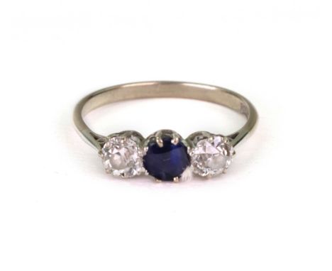 A white gold, diamond and sapphire three stone ring, claw set with circular sapphire to the centre between two circular old c