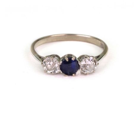 A white gold, diamond and sapphire three stone ring, claw set with circular sapphire to the centre between two circular old c