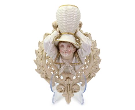 A Royal Worcester glazed parian wall bracket, 1880's, modelled as the head and shoulders of a boy carrying a basket on his he