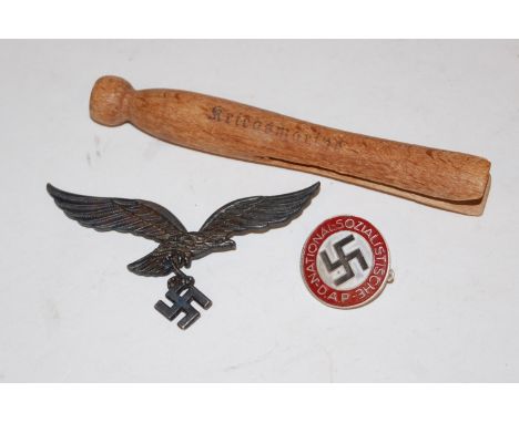 A modern German NSDAP enamel badge together with one other Swastika badge and a clothes peg