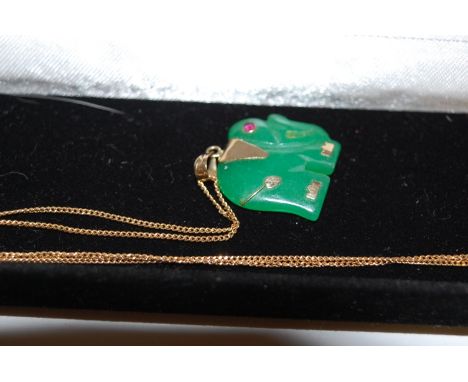 A modern green jade carved elephant pendant on yellow metal mounts, and on 9ct gold fine link neck chain