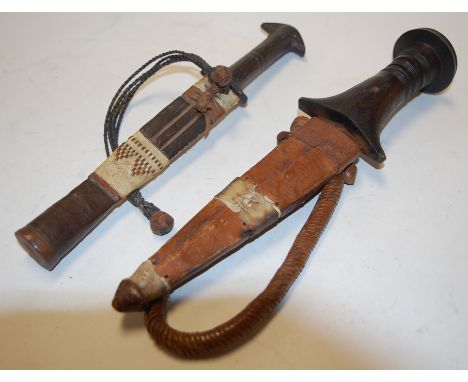 An African dagger in leather sheaf; together with one other similar (2) 