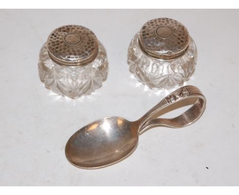 A pair of silver topped glass pill jars, together with a white metal caddy spoon  (2)