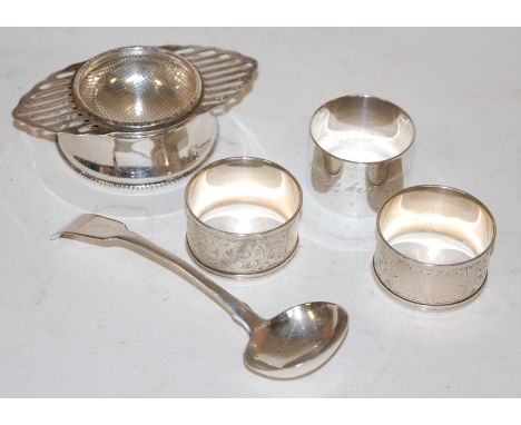 A silver tea strainer on stand, early 19th century silver sauce ladle, and three various silver napkin rings (5)