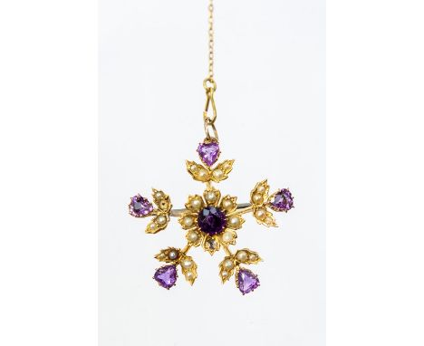 A Edwardian seed pearl and amethyst 9ct gold brooch, comprising a central round cut amethyst with foliate decorative border s