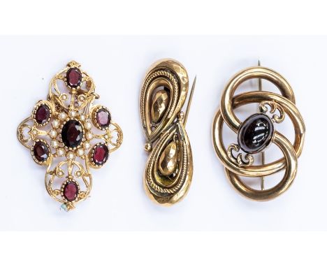 Three early 20th Century 9ct gold brooches, to include a Victorian garnet set brooch comprising a central oval cabochon garne