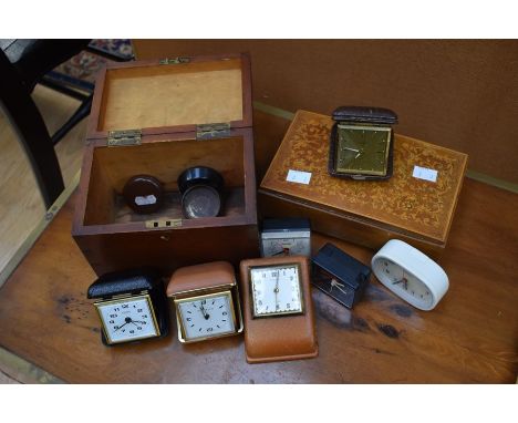 A collection of travel clocks, with a tea caddy and musical box
