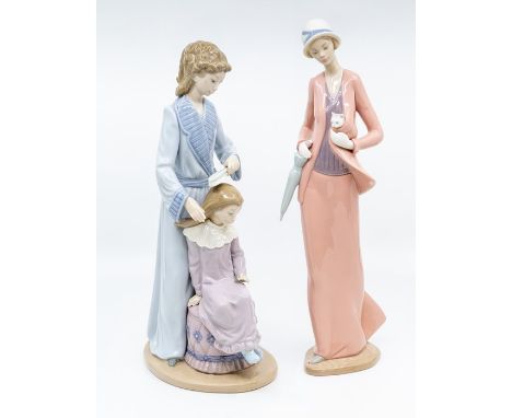 Two Nao figures of women, one is combing a girls hair