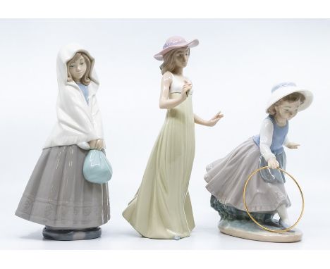 Three Nao figures, two young ladies, one with with hoop
