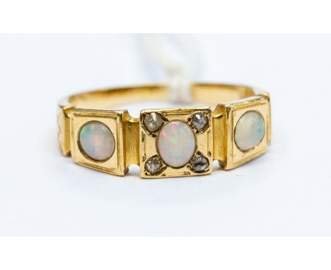 An early 20th Century opal and diamond 18ct gold ring, comprising three oval opals, the central opal set within four diamond 