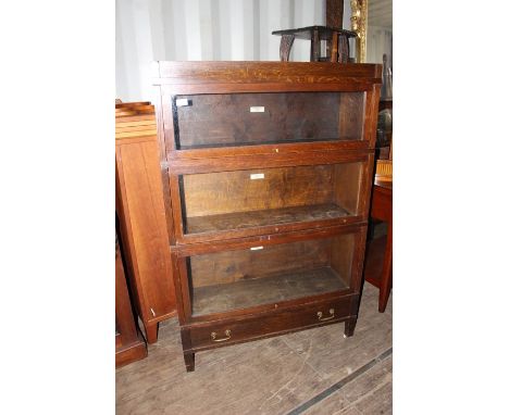 An early 20th Century Globe Wernicke Universal oak stacking bookcase, of three sections, with a drawer to base