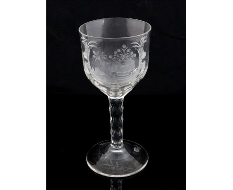 Large 18th century drinking glass, the bowl engraved with a cherub by a table with flowers and foliage, facet cut stem the do