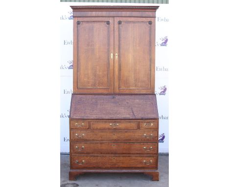George III oak and crossbanded mahogany bureau bookcase, the dentil cornice over a pair of panelled doors enclosing adjustabl