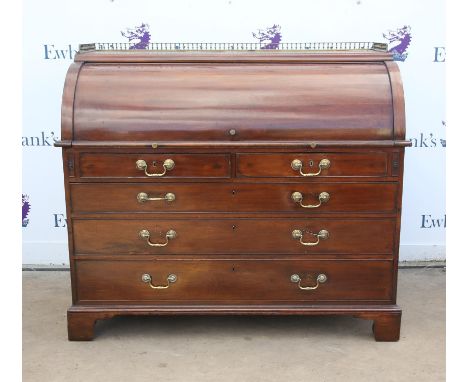 Early 19th century mahogany cylinder bureau, the brass gallery over a writing slide opening to reveal pigeonholes, above two 