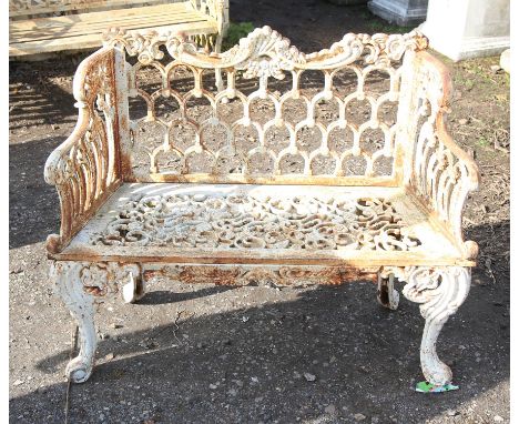 Victorian painted cast iron bench, the scroll and multi-arched back and scroll arms over a floral scroll pierced seat and cab