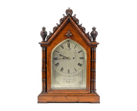 Victorian walnut cased bracket clock, the lancet arched carved case with foliate finials and cluster columns, enclosing a sil