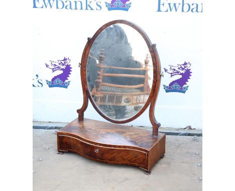 Early 19th century mahogany and boxwood strung toilet mirror, the oval plate above a serpentine base with frieze drawer and o