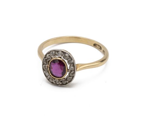 An Edwardian ruby and diamond cluster ring, the oval cut stone enclosed by old single cut diamonds, finger size Q, 3g gross.