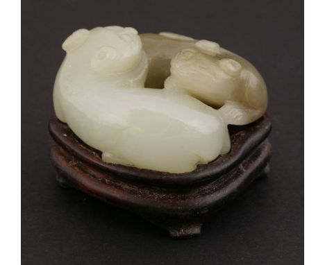 A jade Carving,19th/20th century, of two playful cats, the stone a pale green to light brown, 4.3cm, wood stand (2)十九/二十世纪 玉猫
