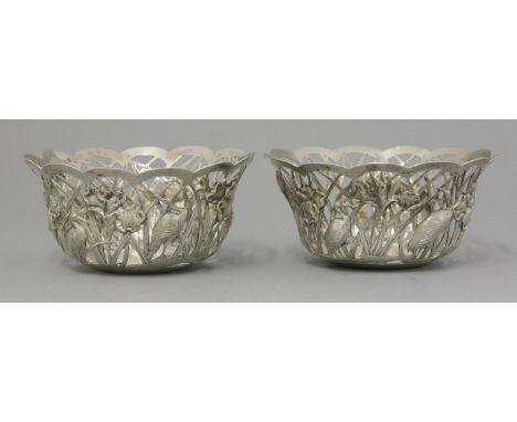A pair of silver Bowls,early 20th century, by Sincere, Hong Kong, cast with relief herons amongst iris against a reticulation
