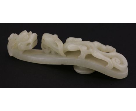 A jade Belt Hook,early 19th century, the pale grey-green stone carved with a chilong confronting a dragon head,10.5cm清十九世纪初 青