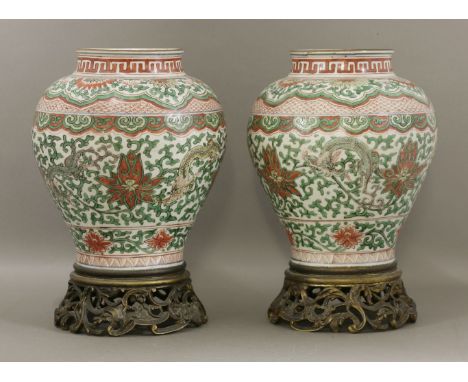 A good pair of wucai Vases,late Ming dynasty, each baluster body with a central band of dragons and lotus within bracket and 