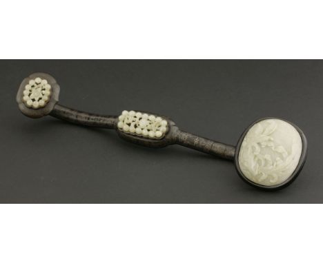 A jade Plaque,possibly 18th century, of oval form, well carved with a leafy plant growing from rockwork, the stone of milky g