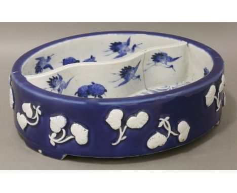 An 'Aesthetic Movement' basin, c.1870, moulded on the low ellipse exterior with white leaves against a deep blue ground, the 